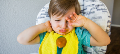 Toddler with dirty bib crying.