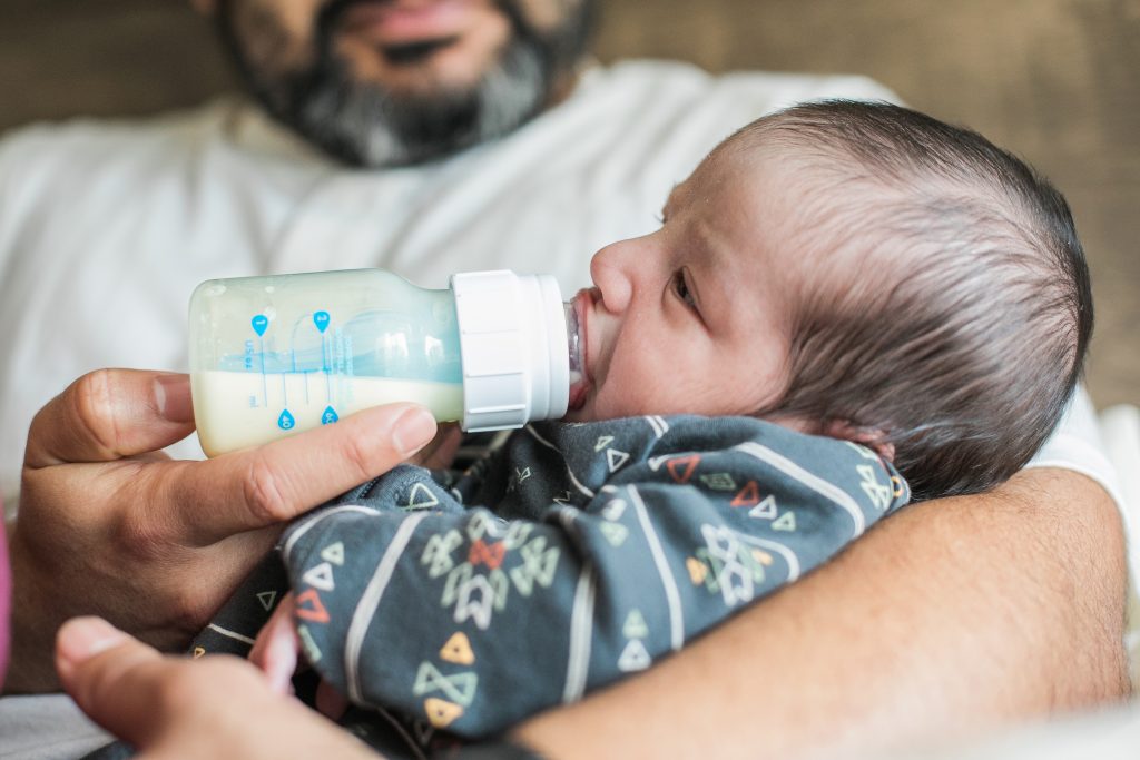 Father feeding baby a bottle of formula