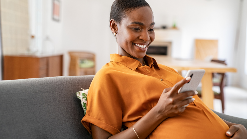 Pregnant woman looking at her phone using an app