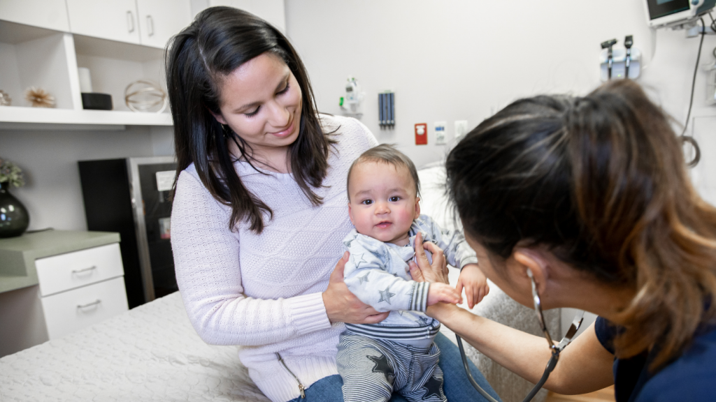 Nurse checking baby's heartbeat with stethoscope