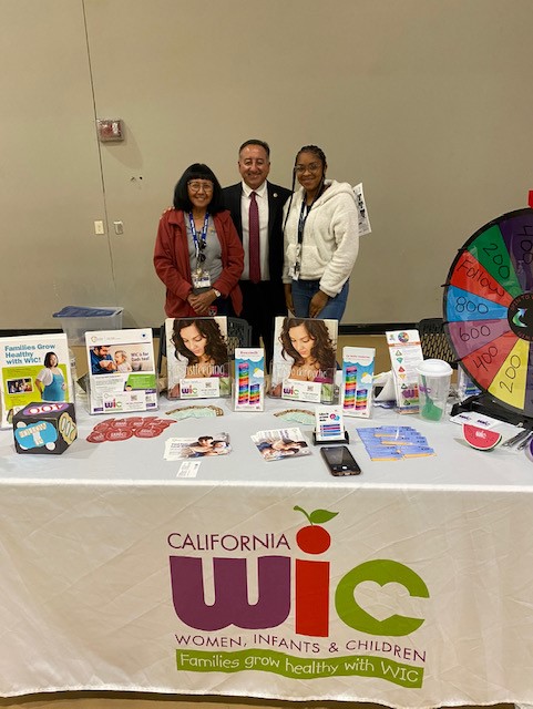 WIC Promotional Stand with Joe Baca, Jr. (Supervisor - Fifth District) and Two Women