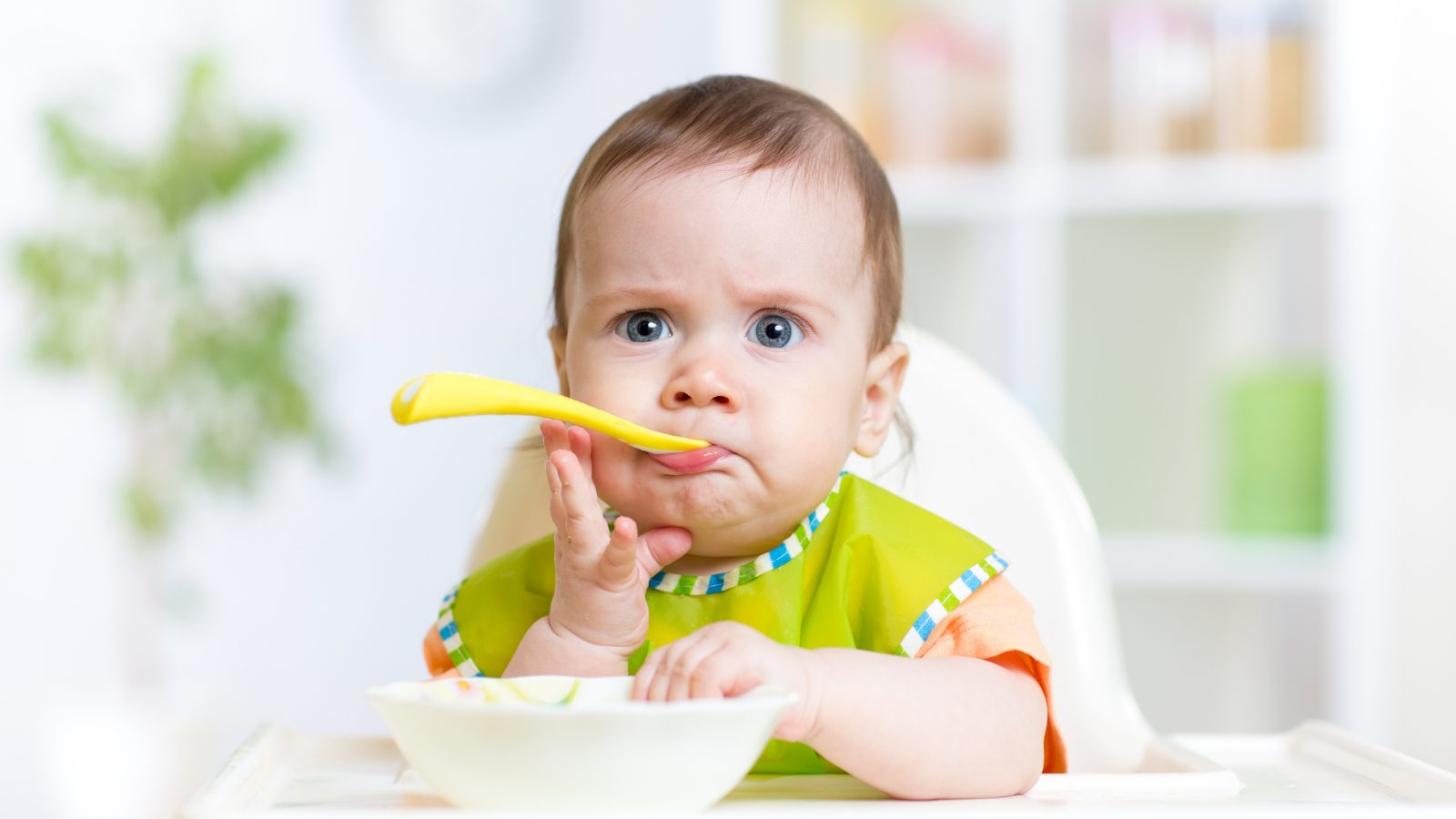 Too Soon for Solids Infant eating solid food from a bowl.